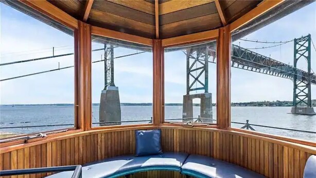 A corner seating area with a view of a bridge. - Iconic Bristol Ferry Lighthouse (Bristol)