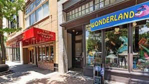 A street view with a brick sidewalk, a parking meter, and storefronts including 'The Lobster Trap' and 'Wonderland'.