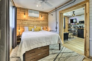 A bedroom with a wooden wall, a bed with a white duvet, and a small desk with a chair. - Near Cubs Spring Training! Couples Retreat in Mesa (Mesa)