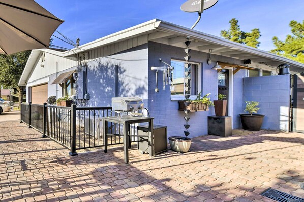 A compact outdoor kitchen area with a grill, a table, and potted plants. - Near Cubs Spring Training! Couples Retreat in Mesa (Mesa)