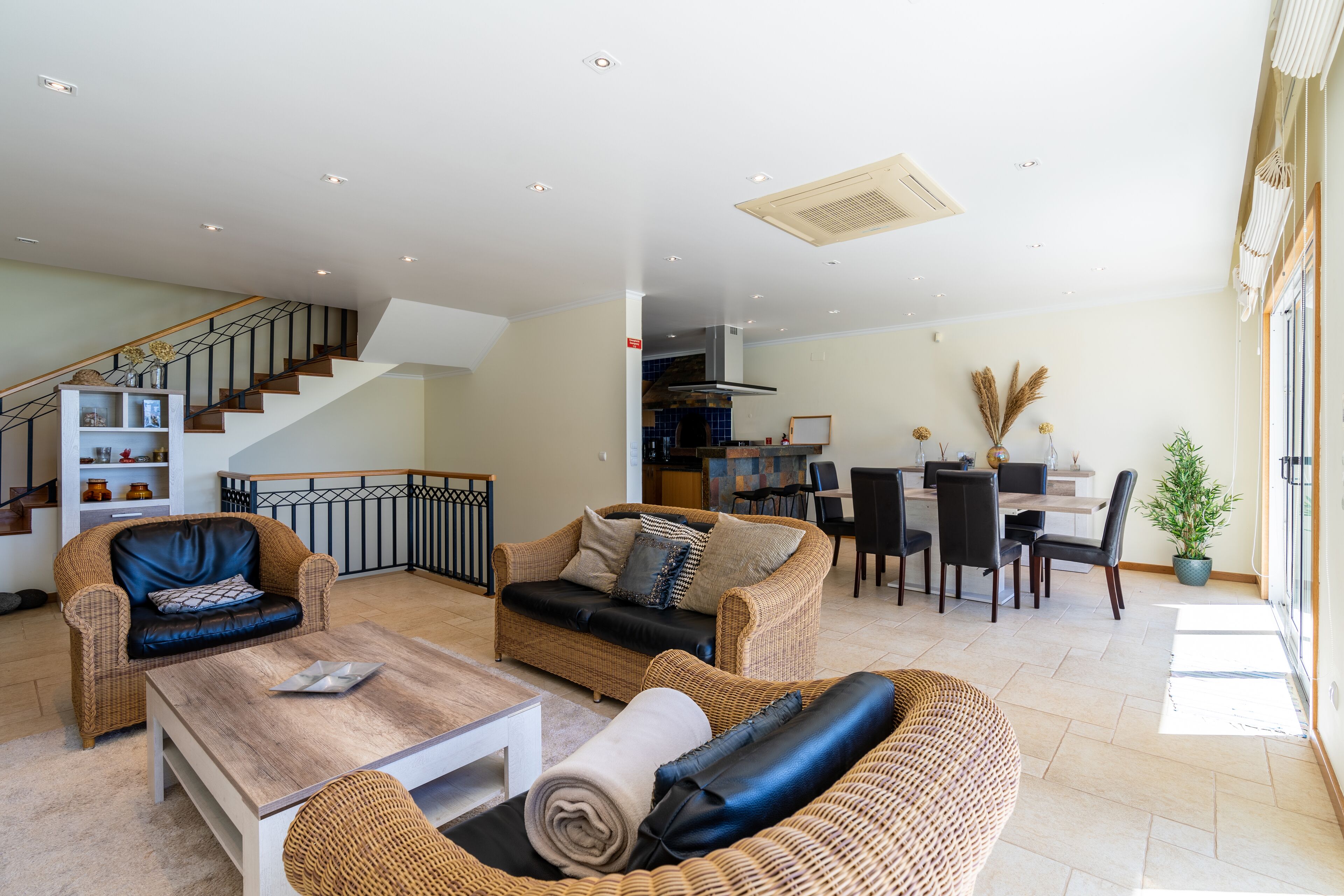A spacious living area with a staircase, a dining area, and a kitchen.
