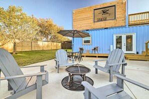 A patio area with Adirondack chairs, a round table, and an umbrella. - Canyon Lake Retreat w/ Pool ~ 2 Mi to Lake (Canyon Lake)