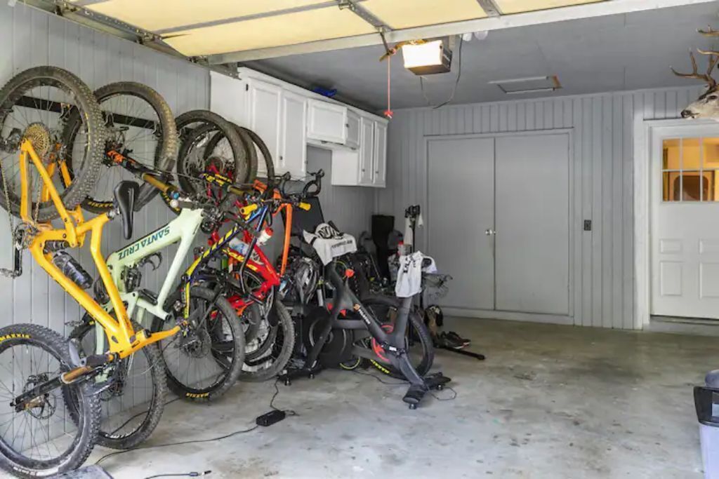 A garage with bicycles and a deer head decoration.