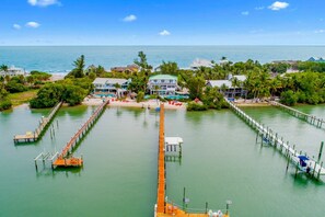 A coastal property with a pier, swimming pool, and beachfront villas.