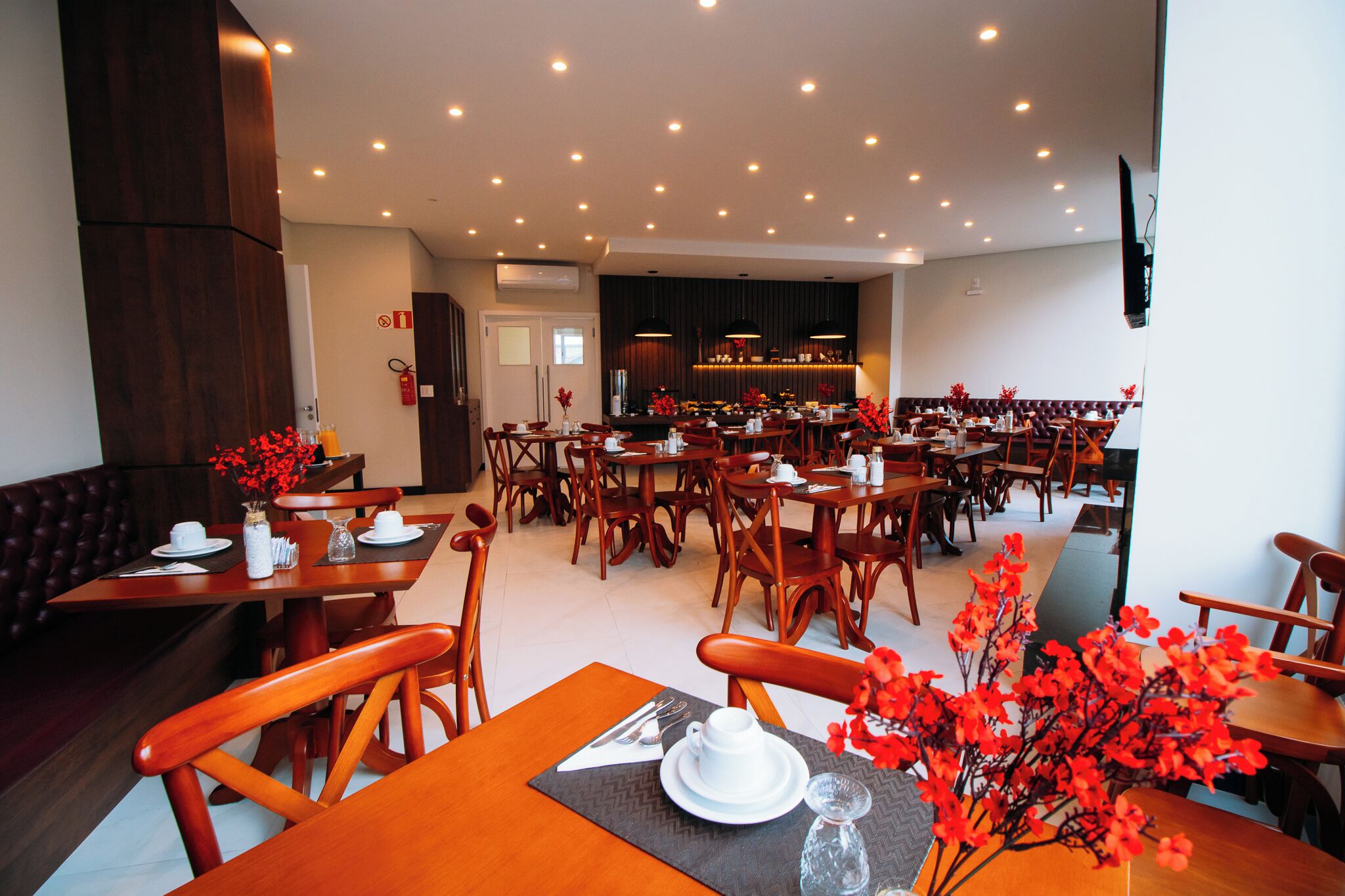 A spacious restaurant with multiple dining tables and chairs, a bar area, and a fireplace.