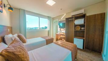 A hotel room with two beds, a desk, a TV, and a wardrobe.