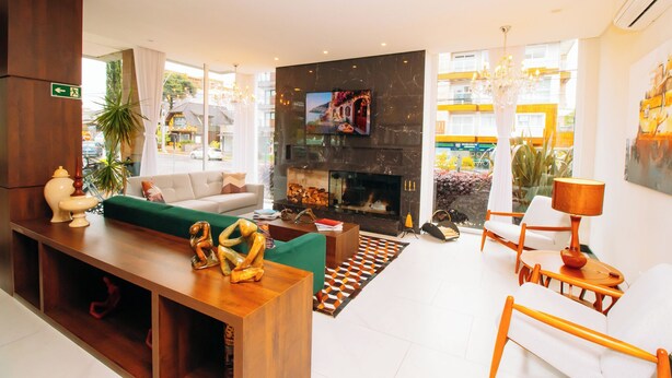 Un moderno vestíbulo de hotel con chimenea, asientos cómodos y una pantalla grande.