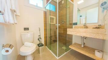 A modern bathroom with a glass-enclosed shower, a toilet, and a sink with a marble countertop.