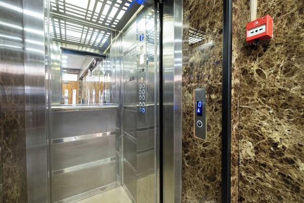 An elevator interior with metallic walls and a marble floor. - Lavin Hotel & Suites (Istanbul)