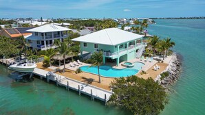 A coastal property with a swimming pool, a dock with a boat, and a view of the ocean. - Direct Oceanfront Private Paradise - Pool/Spa/Dock (Marathon)