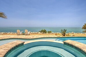 A swimming pool with a curved design, surrounded by a pebble beach and a view of the ocean. - Direct Oceanfront Private Paradise - Pool/Spa/Dock (Marathon)