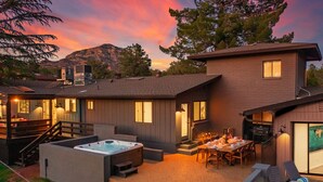 A modern house with a hot tub, outdoor seating, and a mountain backdrop. - 5BR/Heated Pool/Hot Tub/Fire Pit/Views/Sauna/Pets OK (Sedona)