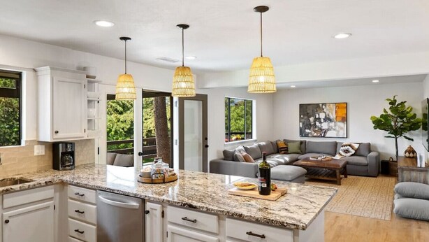 A modern kitchen with granite countertops, white cabinetry, and pendant lighting. - 5BR/Heated Pool/Hot Tub/Fire Pit/Views/Sauna/Pets OK (Sedona)