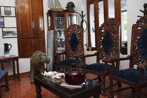 A traditional room with wooden furniture, a cabinet with glass doors, and a decorative ship on top. - Hotel Boutique Casa Aduana (Topolobampo)