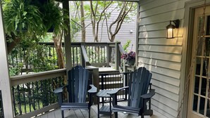 Un portico coperto con poltrone Adirondack, un tavolino e un'altalena.
