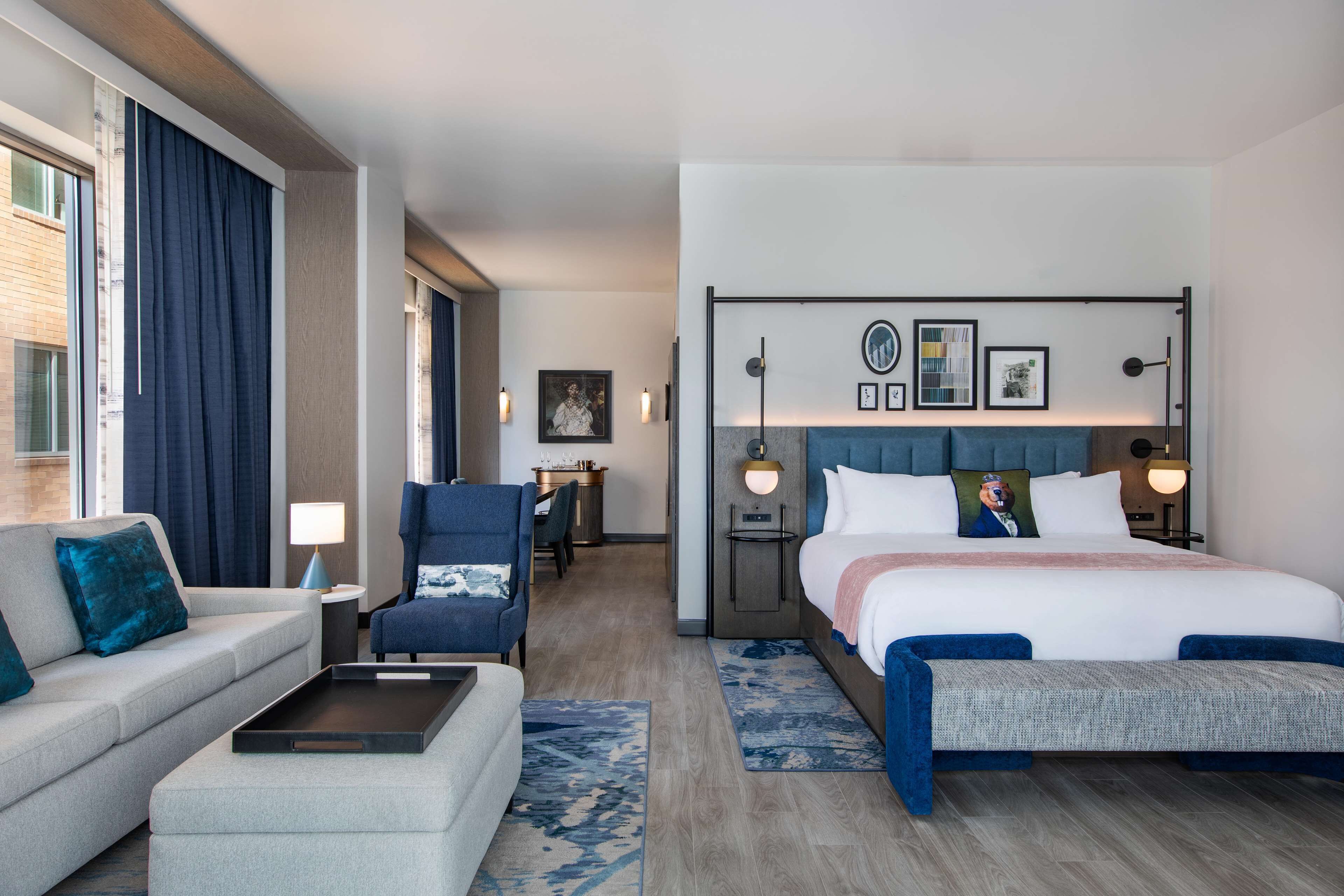 Una habitación de hotel con una cama, un sofá, una silla, un escritorio y una mesita.