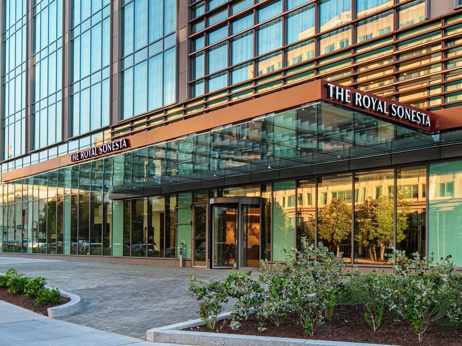 A modern hotel with a glass facade and signage reading "The Royal Sonesta."