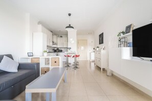 A modern apartment with a living area, kitchen, and dining space.