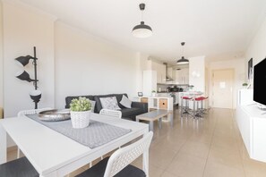 A modern living space with a dining area, kitchen, and seating area.