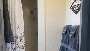 A small bathroom with a toilet, a shower, and a towel rack. - Cabin 21 - Bicycle Retreat (Helena)