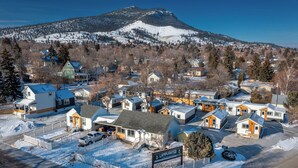 Zona residencial cubierta de nieve con un cartel que dice 'LAMPLIGHTER CABINS & SUITES'.