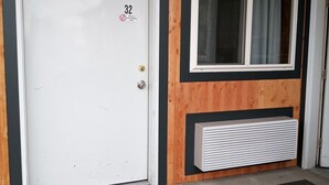 A door with a non-smoking sign, a window, and a radiator on the wall. - Suite 32 - King Suite (Helena)