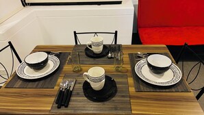 Ein Esstisch mit vier Schüsseln, zwei Gläsern und Besteck.