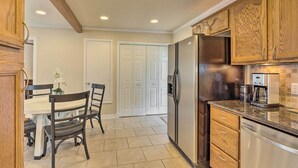 A kitchen with wooden cabinets, a stainless steel refrigerator, and a coffee maker.
