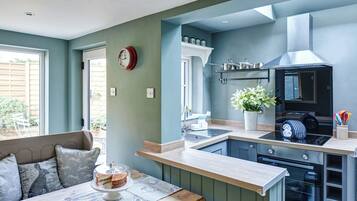 A modern kitchen with a built-in oven, a sink, and a dining area with a table and chairs.
