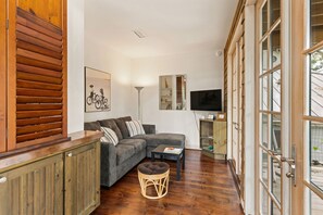 A living room with a sectional sofa, a small round table, and a television.