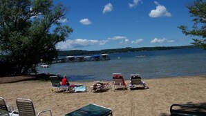 Une plage avec des chaises longues et vue sur le lac.