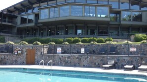 Un bâtiment moderne doté d’une piscine et de chaises longues.