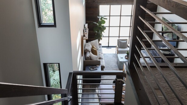 A staircase leading to a living area with a sofa, a coffee table, and a plant. - CENTRAL Modern Condo!! 4 Mins to Airport, Mins to Downtown Bozeman! (Belgrade)