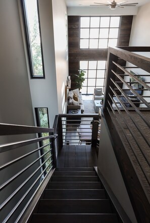 A staircase leading to a living area with a sofa, a coffee table, and a plant.