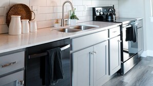 A modern kitchen with white cabinets, a stainless steel oven, and a microwave. - CENTRAL Modern Condo!! 4 Mins to Airport, Mins to Downtown Bozeman! (Belgrade)