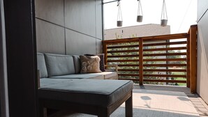 A modern outdoor seating area with a sofa and bench, a wooden pergola, and a view of greenery. - CENTRAL Modern Condo!! 4 Mins to Airport, Mins to Downtown Bozeman! (Belgrade)
