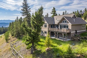 A large two-story house with a balcony, surrounded by trees and a view of mountains. - BRAND NEW LISTING! Gorgeous Private Big Sky Cabin! (Big Sky)