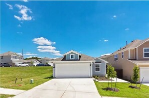 Homes with attached garages and contemporary architecture line the quiet neighborhood streets.