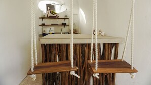 Cocina rústica con una isla de madera y columpios de cuerda colgantes.