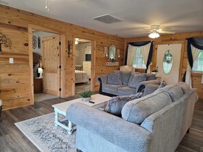 A cozy living room with a grey sofa, a coffee table, and a wooden floor.