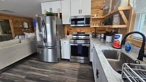 Une cuisine moderne dotée d’appareils électroménagers en acier inoxydable, de touches décoratives en bois et d’un four encastré.