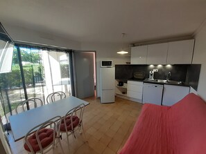 A compact kitchen with a refrigerator, microwave, coffee maker, and sink.
