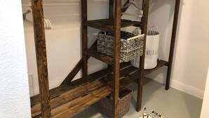 Ein Holzregal mit Handtüchern, Körben und einer weißen Box mit der Aufschrift 'WASH & DO'.
