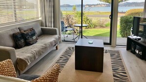Ein modernes Wohnzimmer mit einer Couch, einem Couchtisch und einem Fernseher.