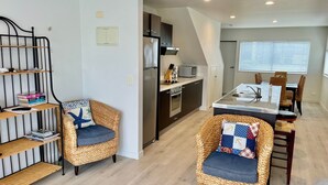 Eine moderne Wohnung mit Küche, Essbereich und zwei Korbstühlen mit Kissen.
