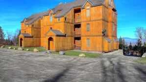 A large wooden building with multiple balconies and a gravel driveway. - South Branch Condo 21-1 - ground level ski-in/out on Saddleback (Sandy River Plantation)