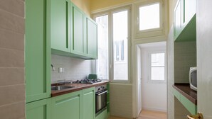 Una cucina con mobili verdi, un fornello e un forno a microonde.