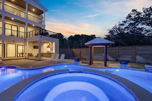 Une maison moderne à deux étages dotée d’une piscine, d’un espace salon extérieur et d’un belvédère.