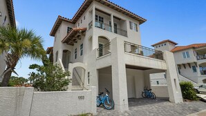 Ein mehrstöckiges Gebäude mit heller Fassade, einem Balkon im zweiten Stock und zwei Fahrrädern vor der Tür.