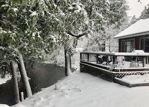 Winter wonderland setting with a serene deck overlooking a tranquil body of water.